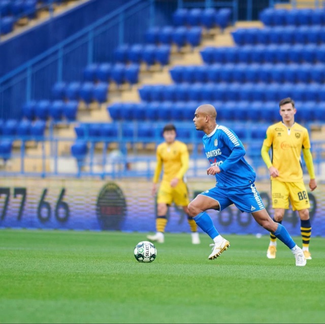 Jonatan conduzindo a bola de uniforme azul